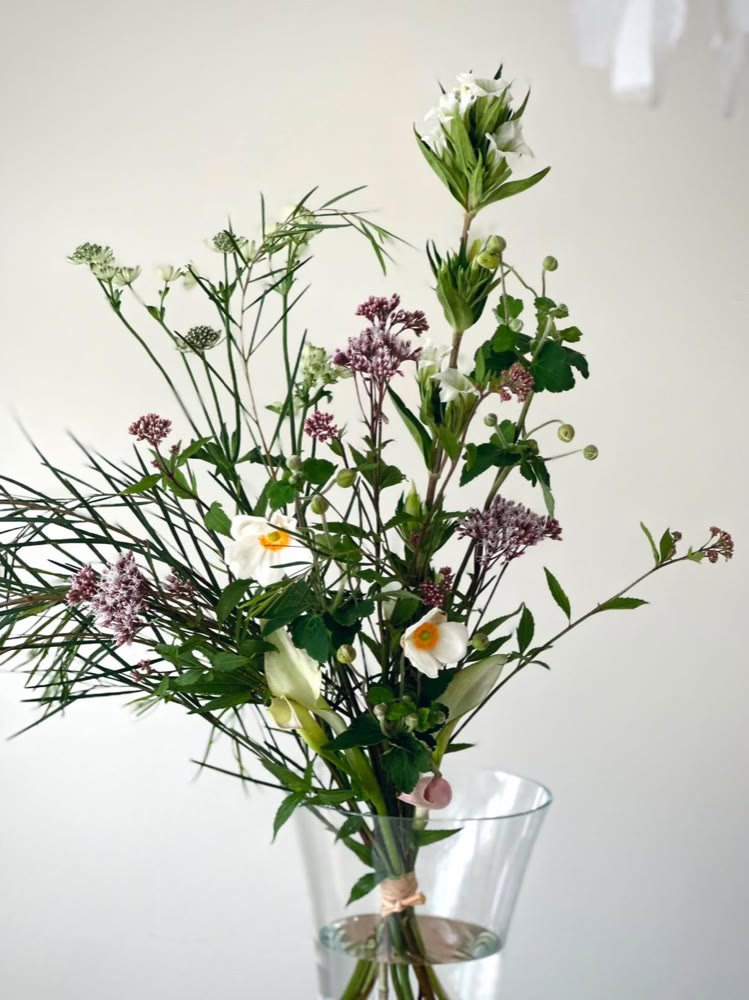 花瓶に生けられた、白とモーブ色の季節のお花のブーケ