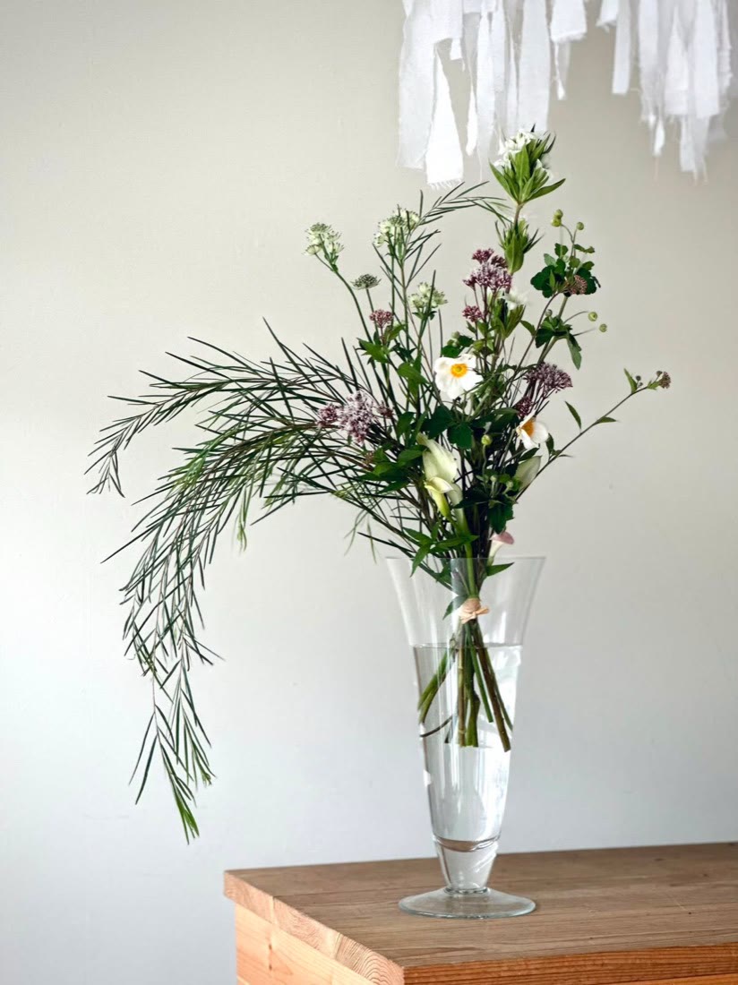 花瓶に生けられた、白とモーブ色の季節のお花のブーケ